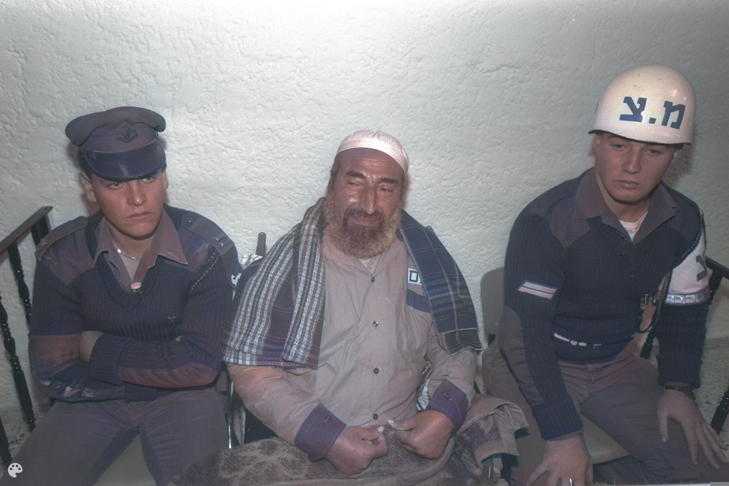 Hamas founder Sheikh Ahmed Yassin (center) sits between Israeli guards during a trial in 1990. [Image: Yonathan Torgovnik]